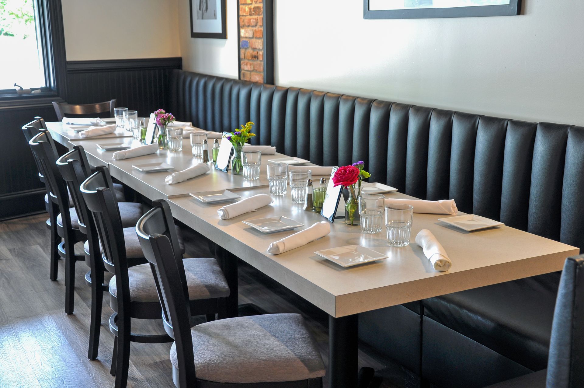 A long table in a restaurant with plates and glasses on it