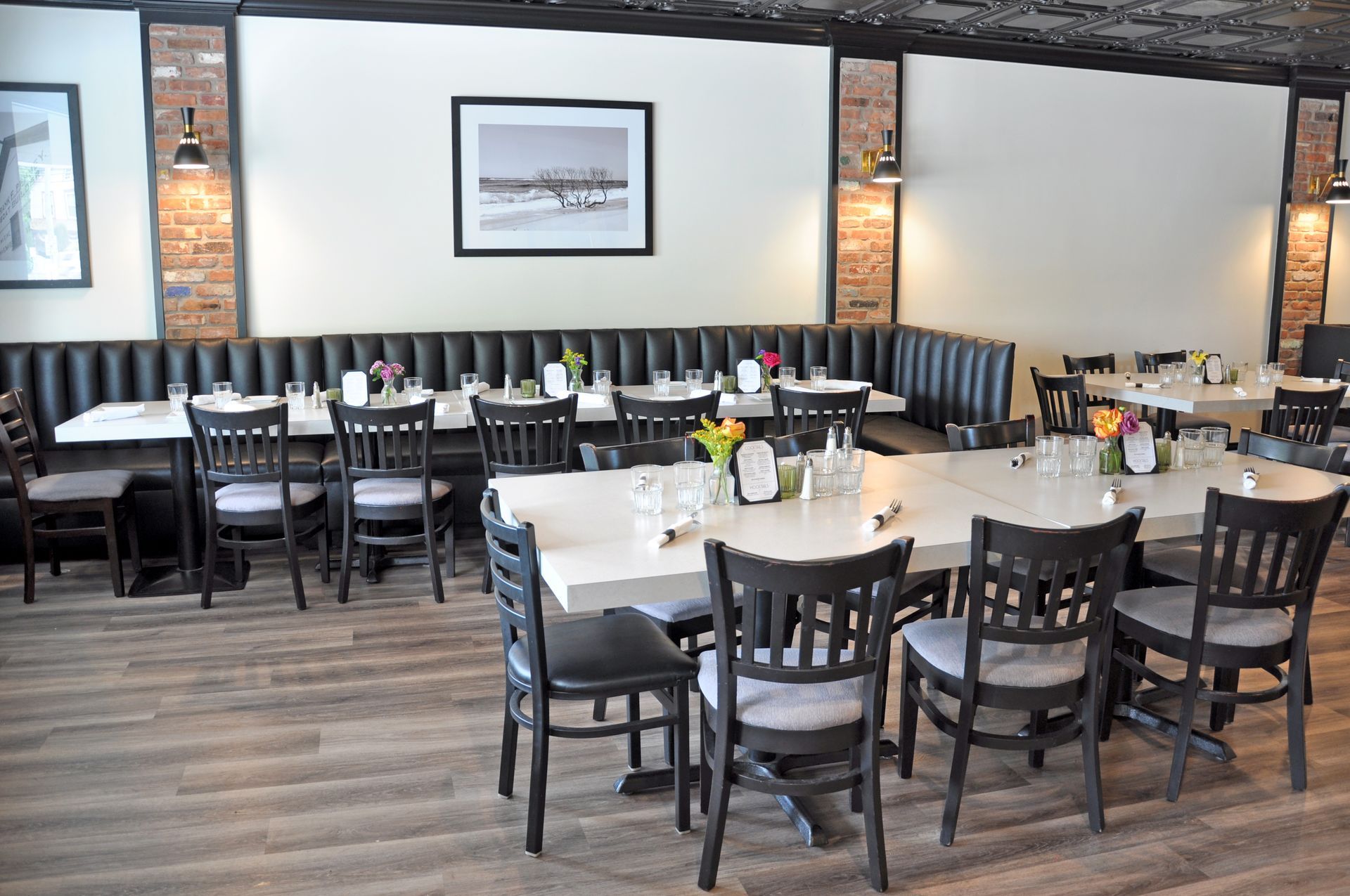 A restaurant with tables and chairs and a picture on the wall.