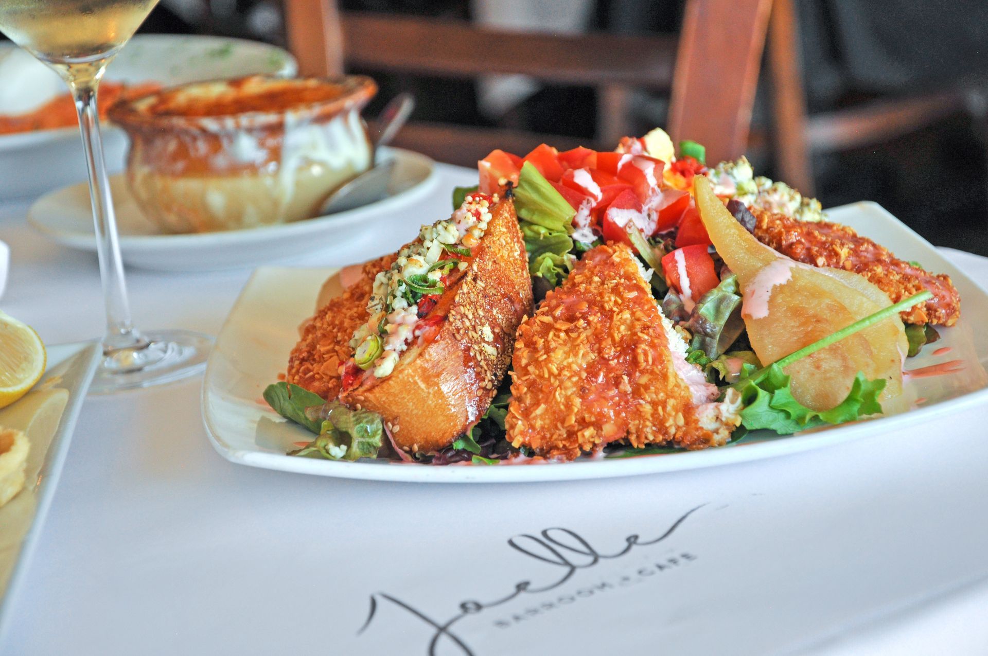 A plate of food on a table with a glass of wine