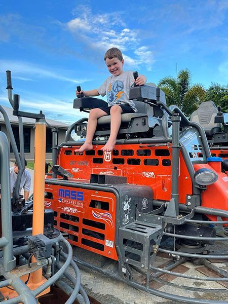 A Young Boy Is Sitting on Top of An Orange Machine — Mass Construction Group Australia Pty Ltd in South Mackay, QLD
