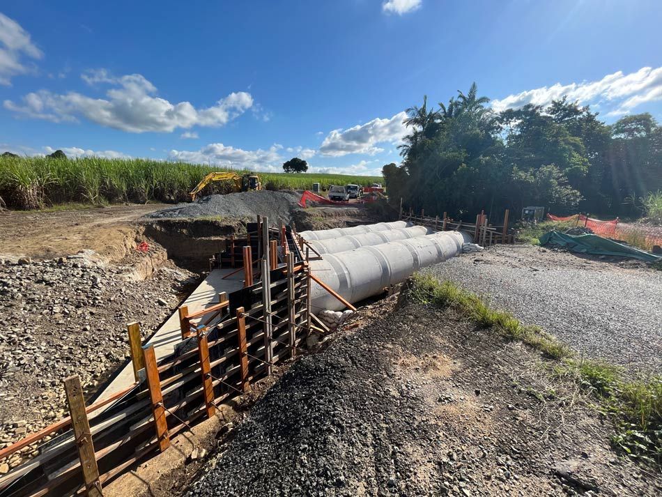 A Construction Site with A Lot of Pipes in The Dirt — Mass Construction Group Australia Pty Ltd in South Mackay, QLD