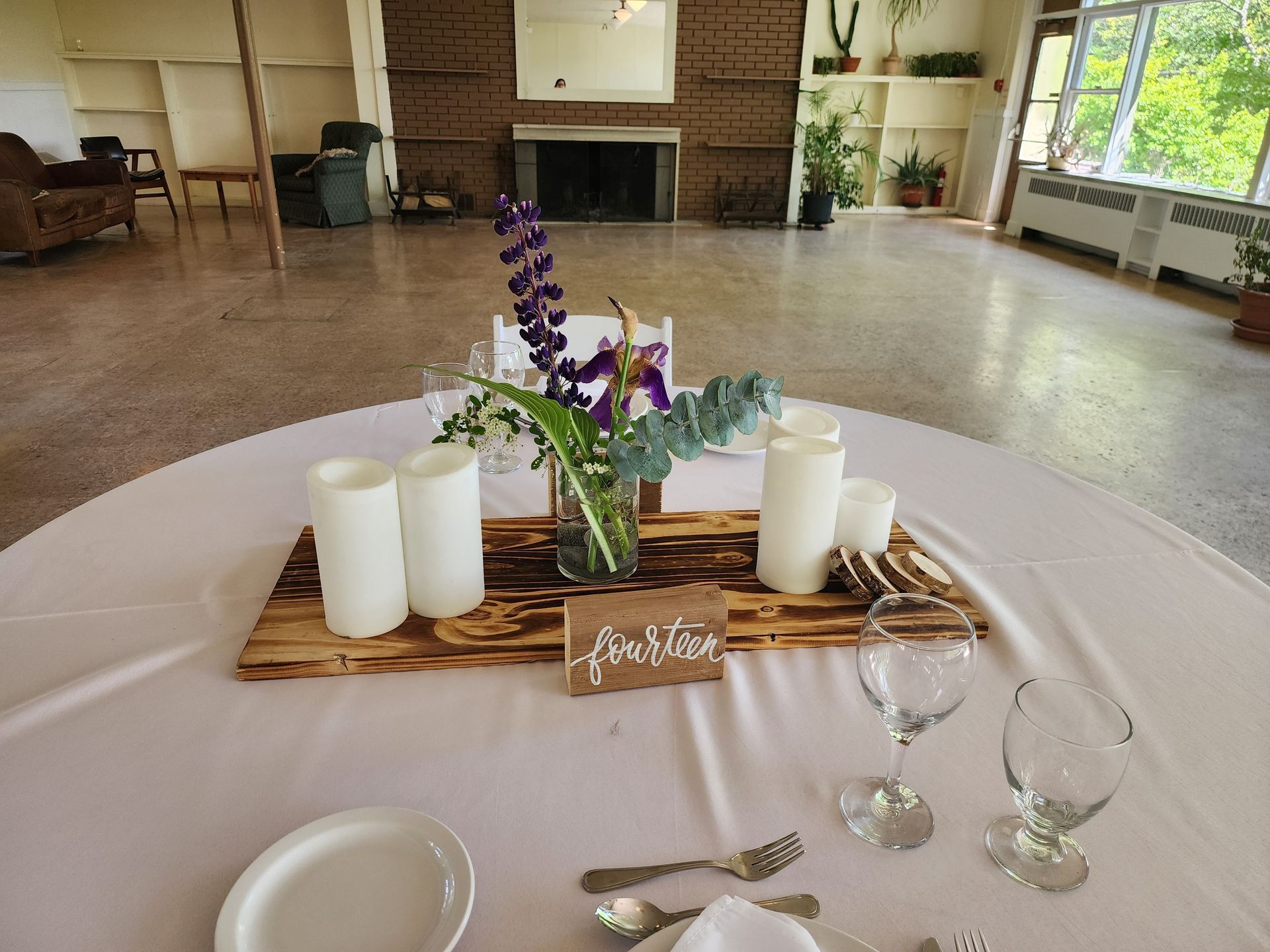 A table with plates , glasses , candles and flowers on it.