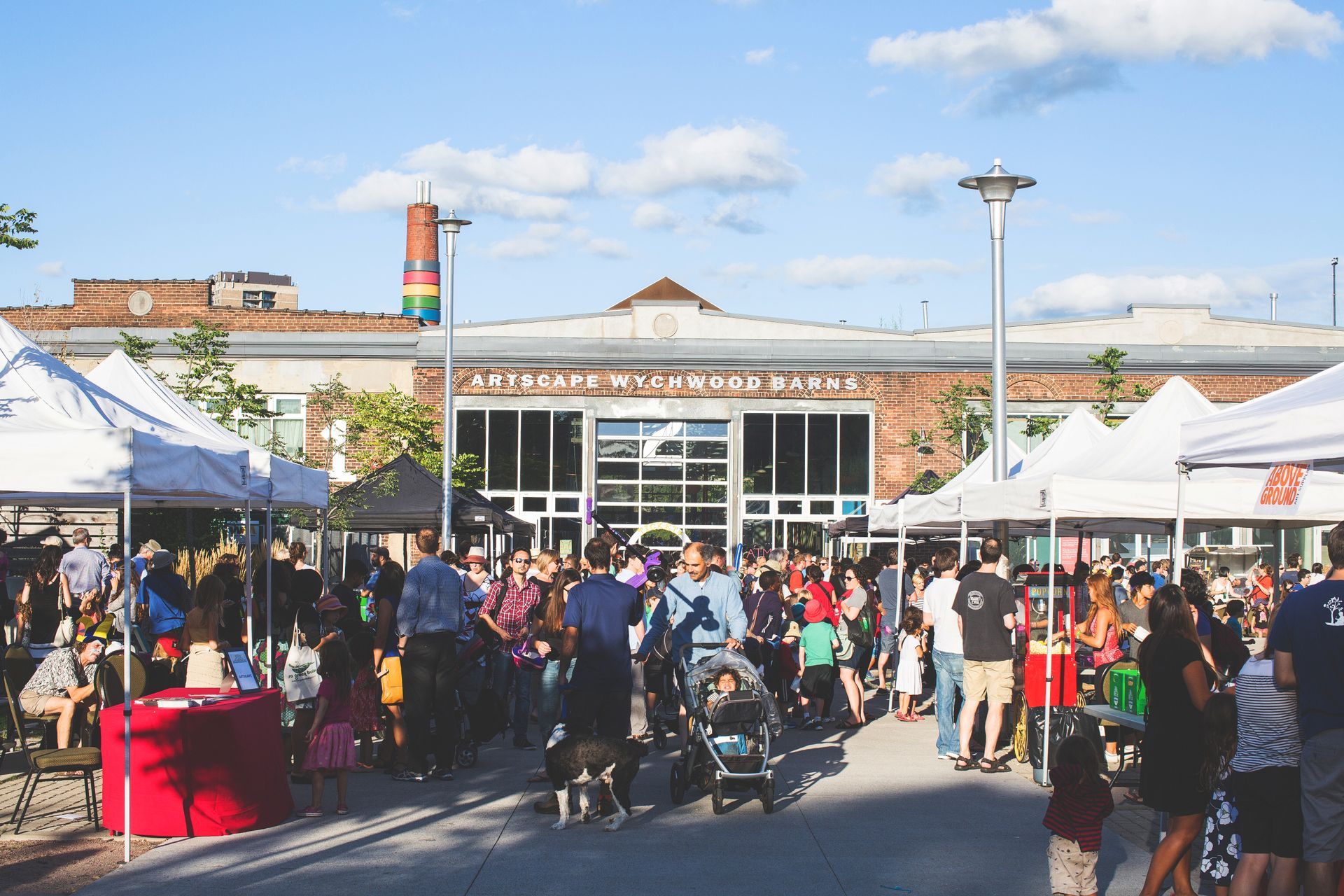 A crowd of people are gathered in front of a building at a market.