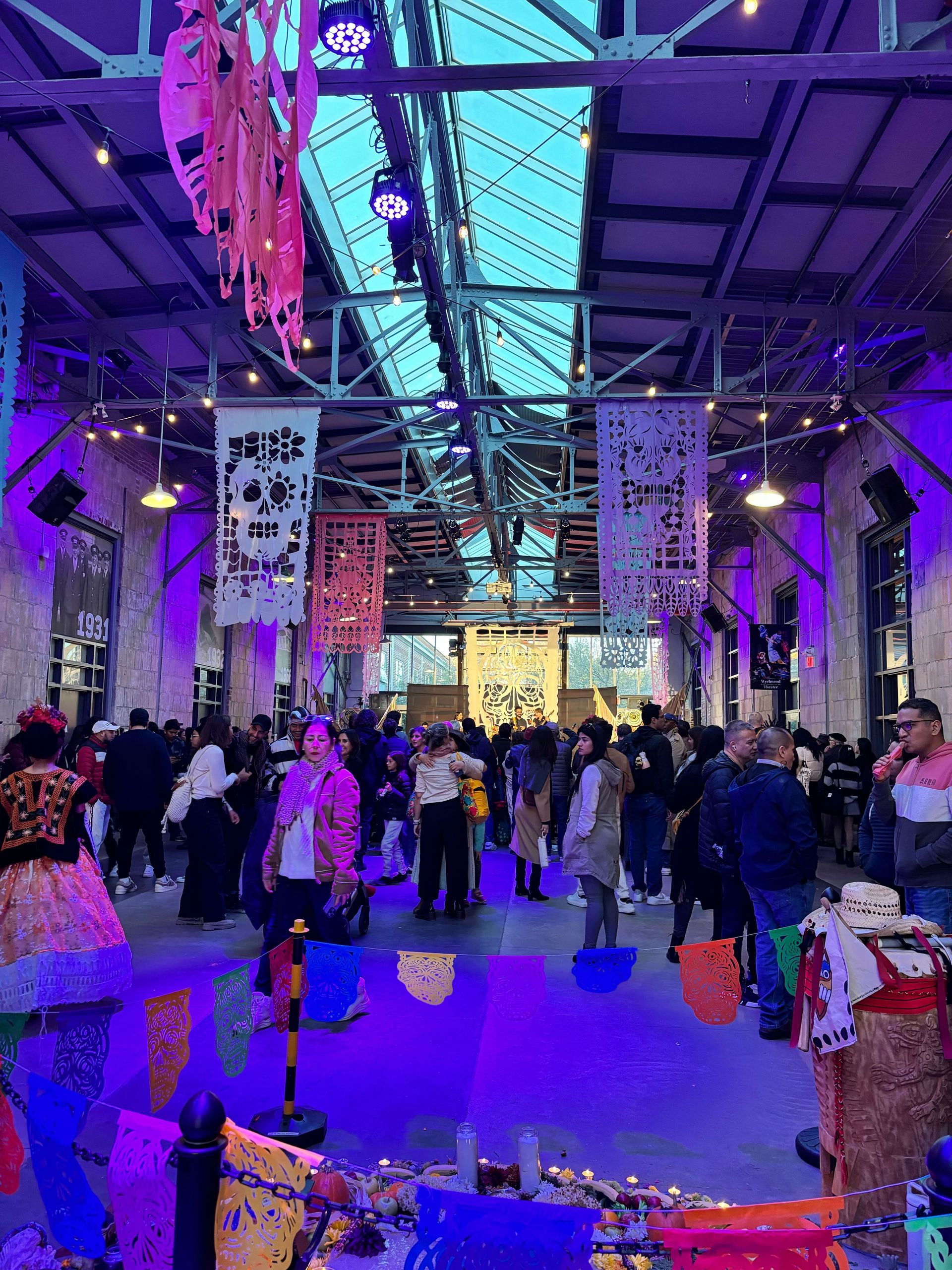 A group of people are standing in a room with purple lights.