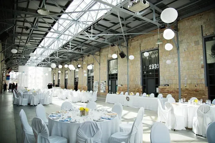 A large room with tables and chairs set up for a wedding reception.