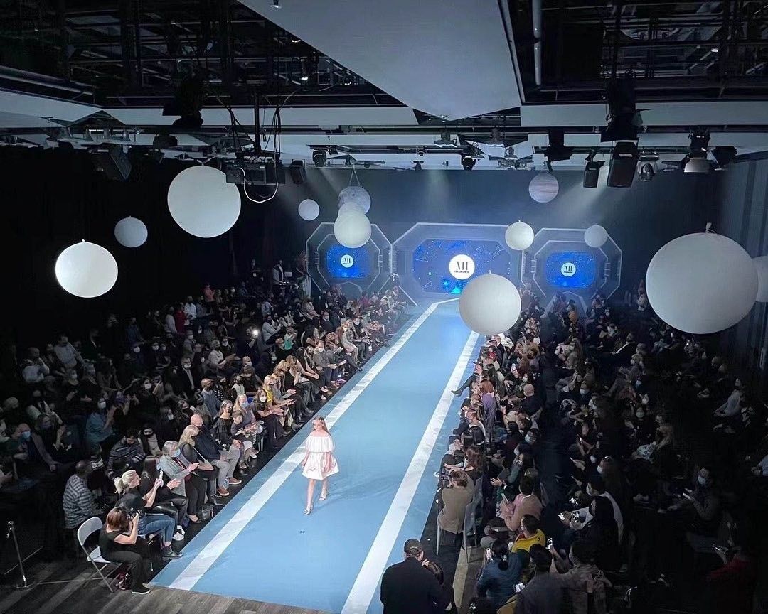 A model walks down a runway at a fashion show