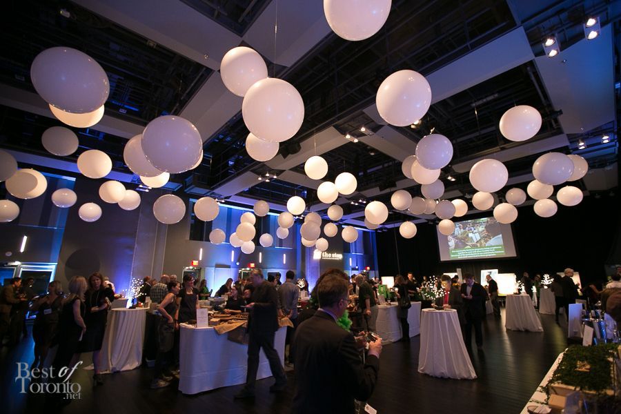 A large room with tables and balloons hanging from the ceiling