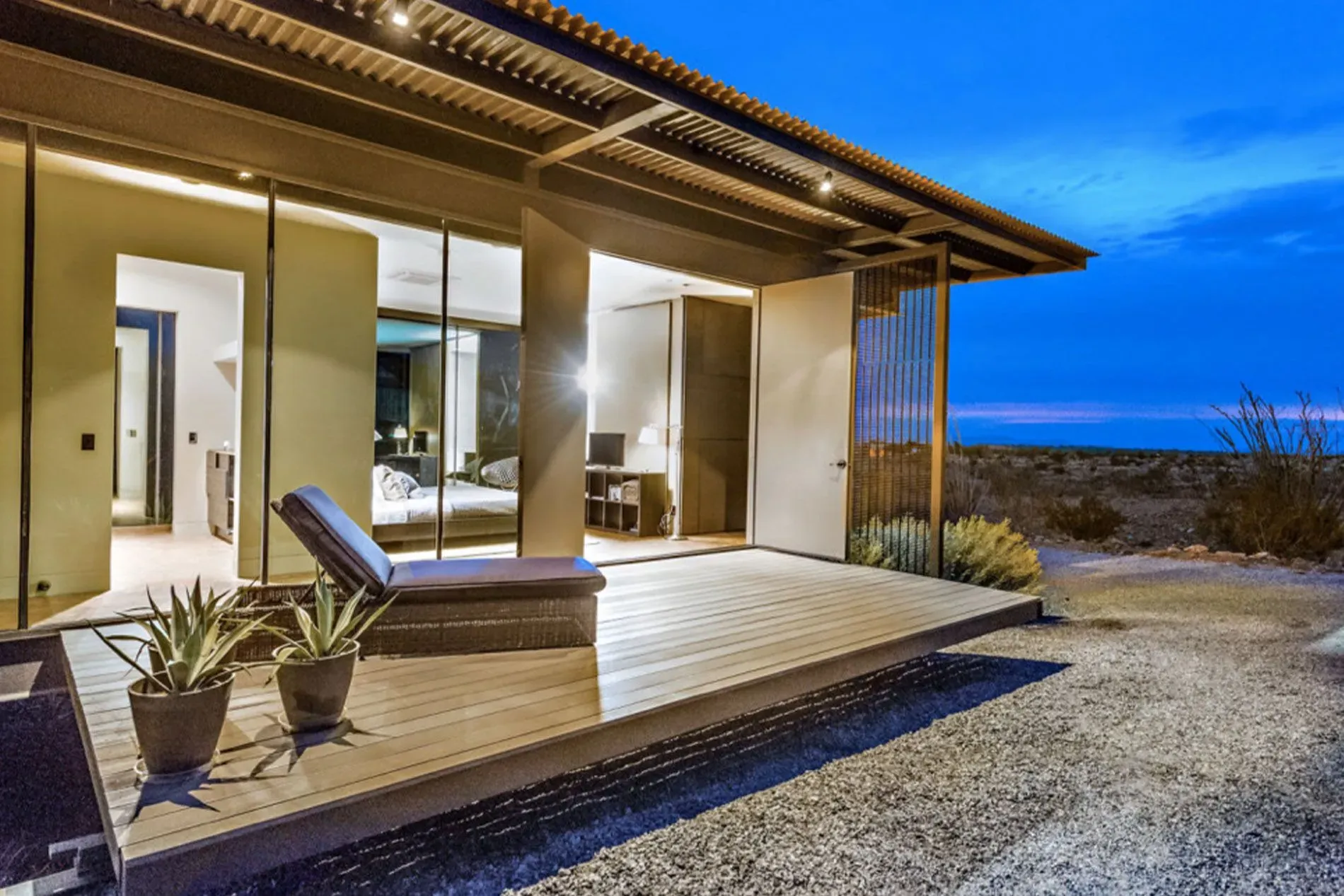 Modern house deck at dusk with a lounge chair.