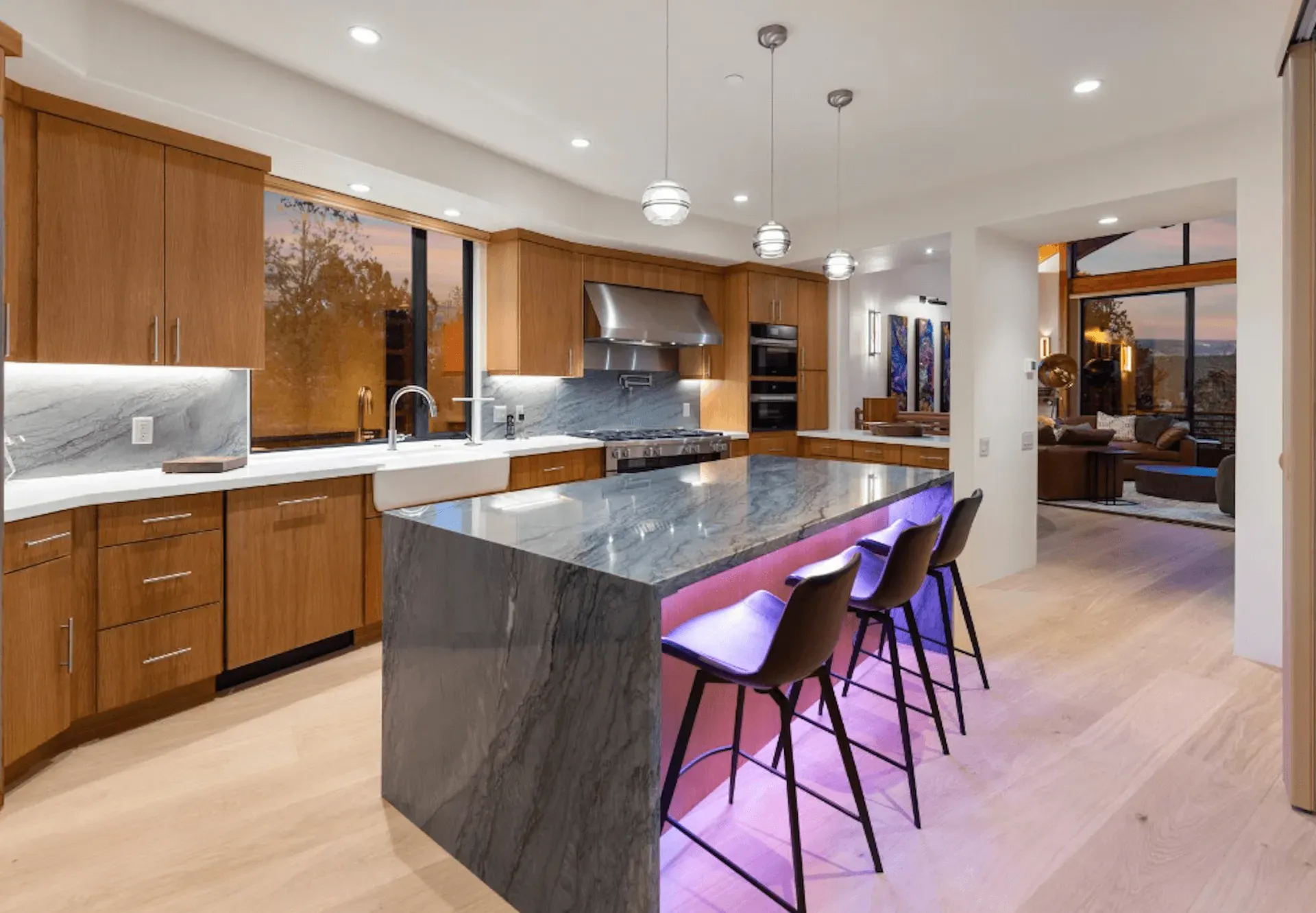 A kitchen with a large island and purple lights.