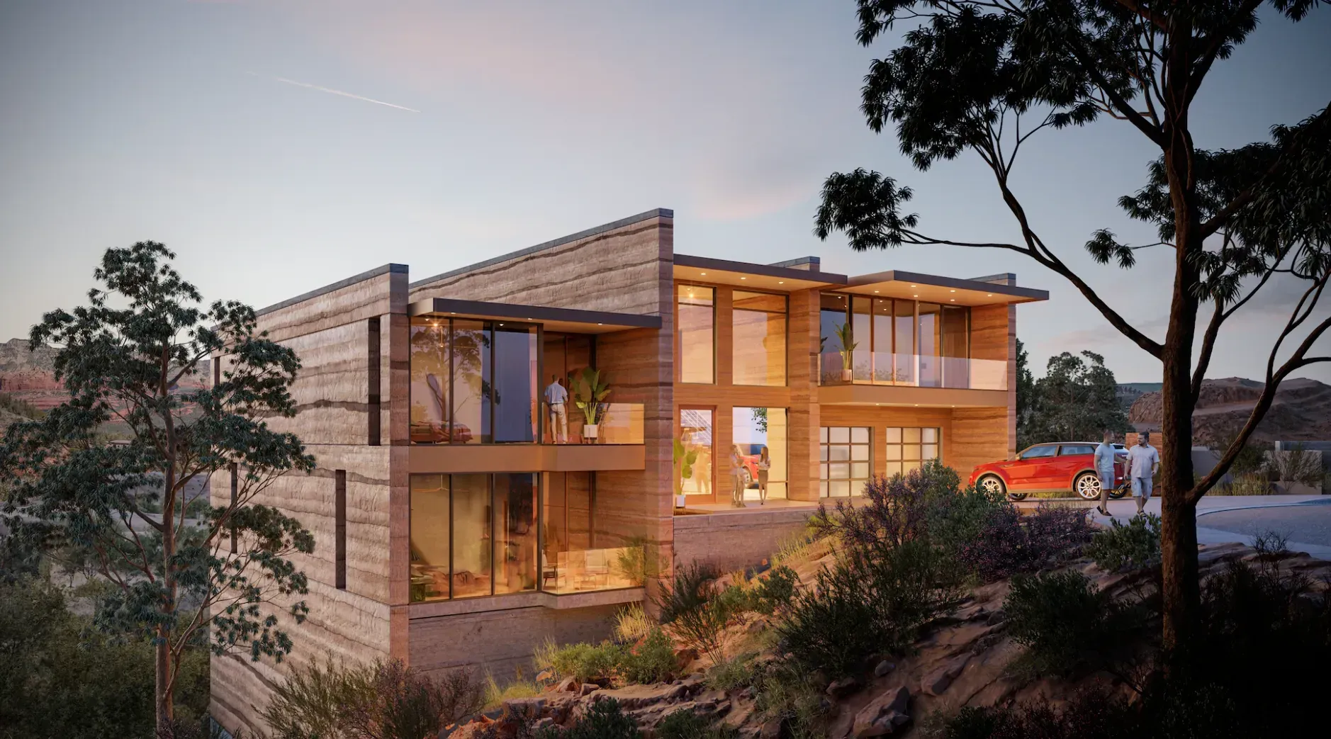 Modern two-story wooden house at dusk with warm lit windows, surrounded by trees and hillside greenery