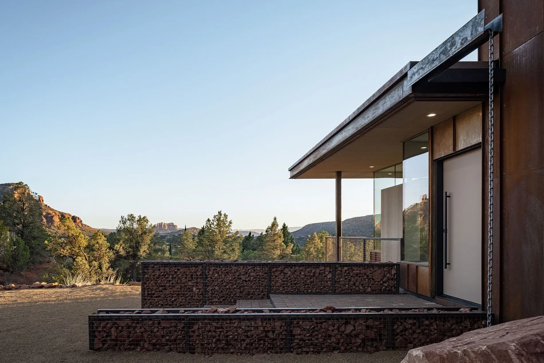 Modern house patio with brick steps, glass railing