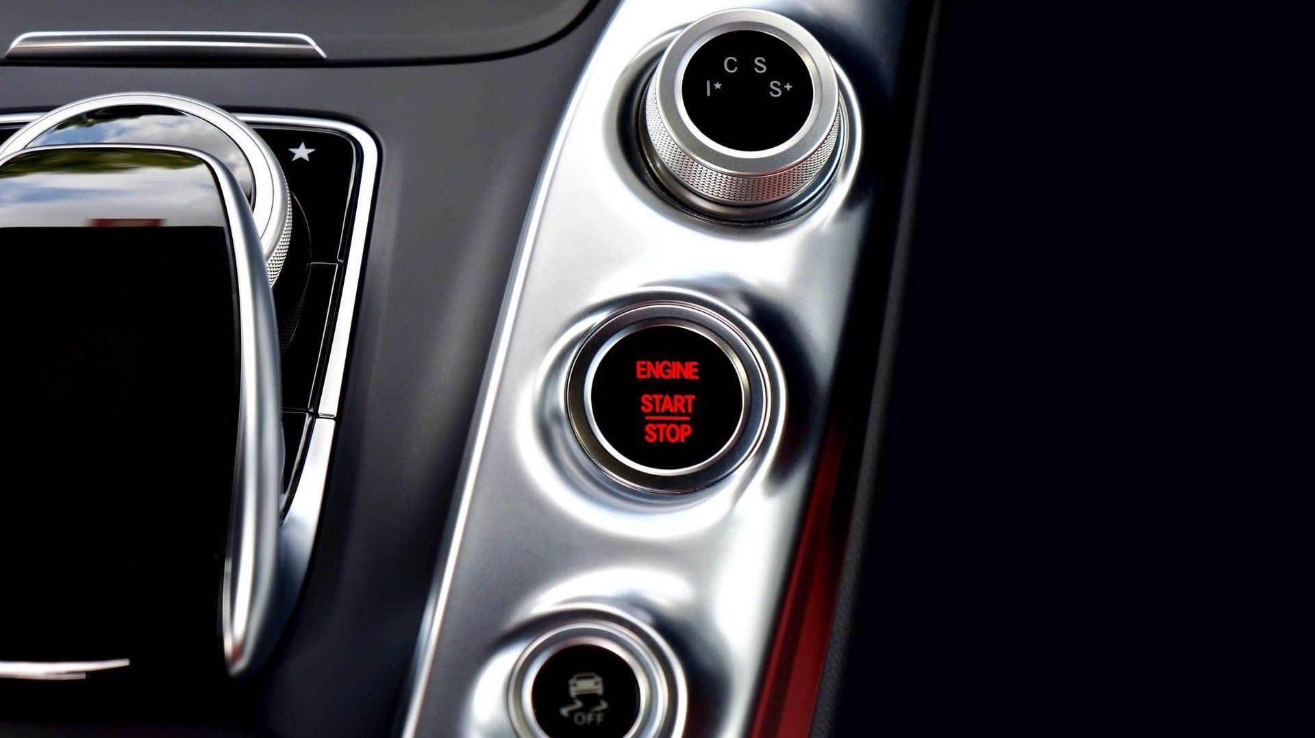 A close up of a car dashboard with buttons for start and stop