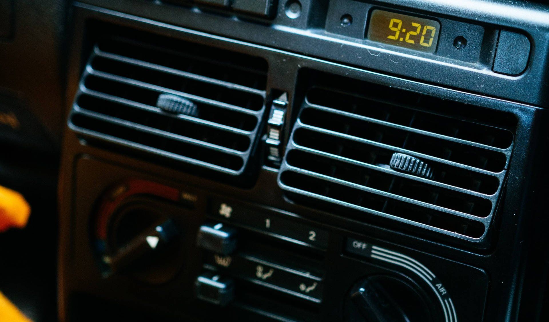 A car dashboard with a digital clock that says 9:20
