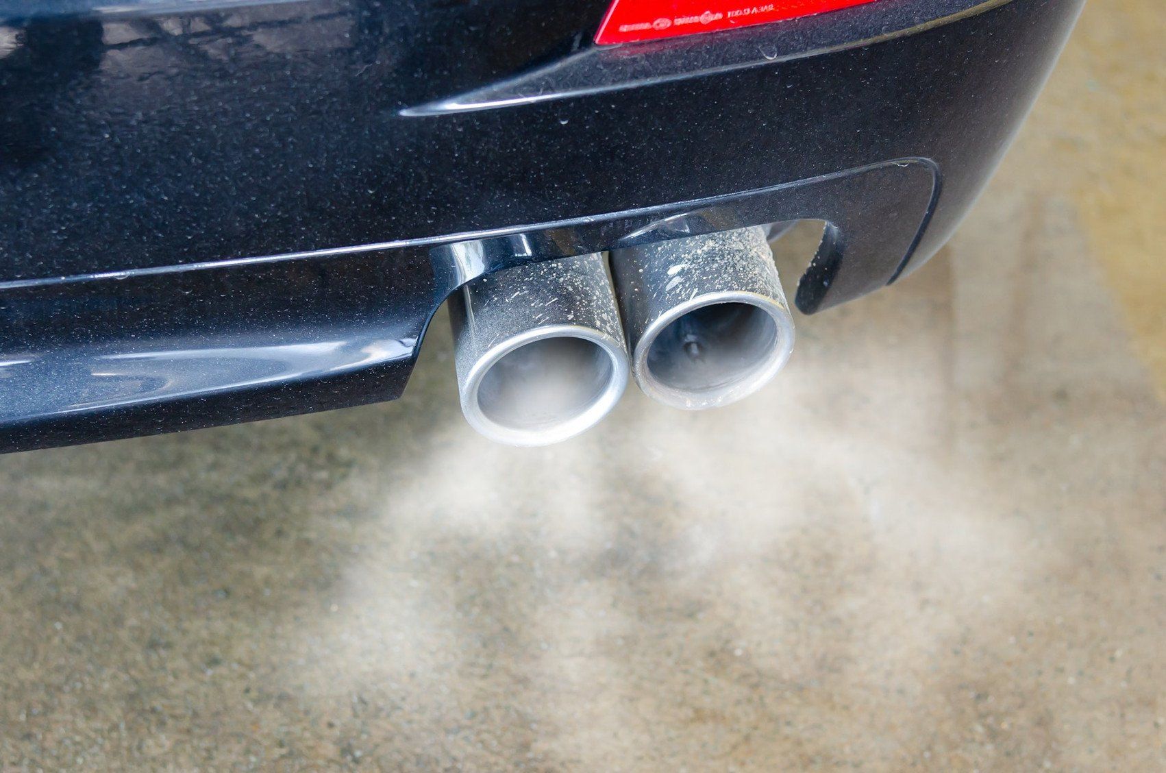 Smoke is coming out of the exhaust pipes of a car