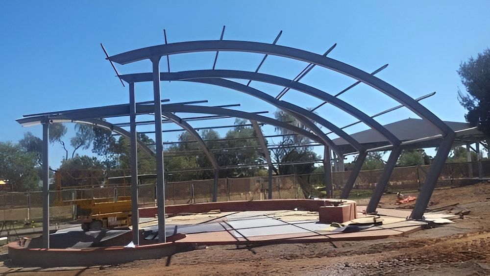 A Large Metal Structure Is Being Built In A Dirt Field — Jakes Steel & Welding in East Arm, NT