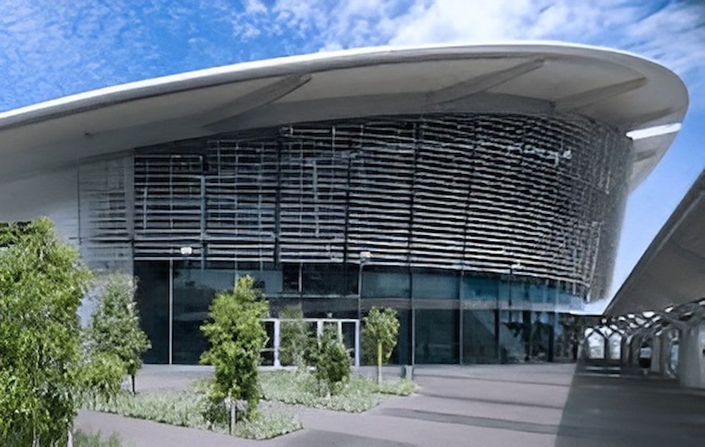 A Large Building With A Curved Roof Is Surrounded By Trees — Jakes Steel & Welding in East Arm, NT