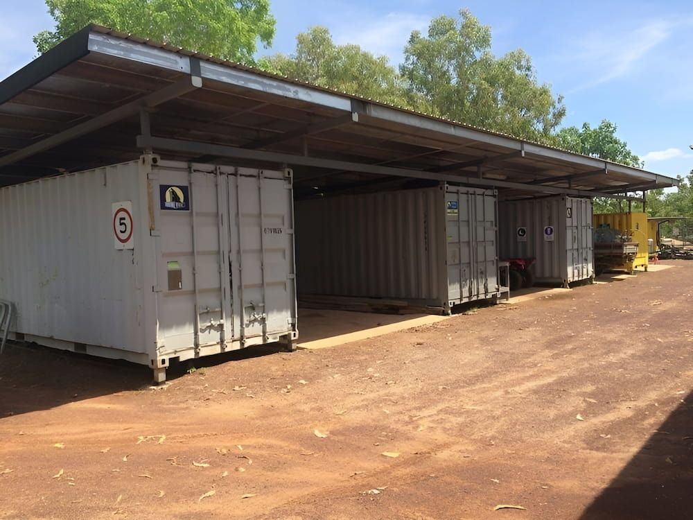 A Row Of Shipping Containers Are Lined Up Under A Roof — Jakes Steel & Welding in East Arm, NT