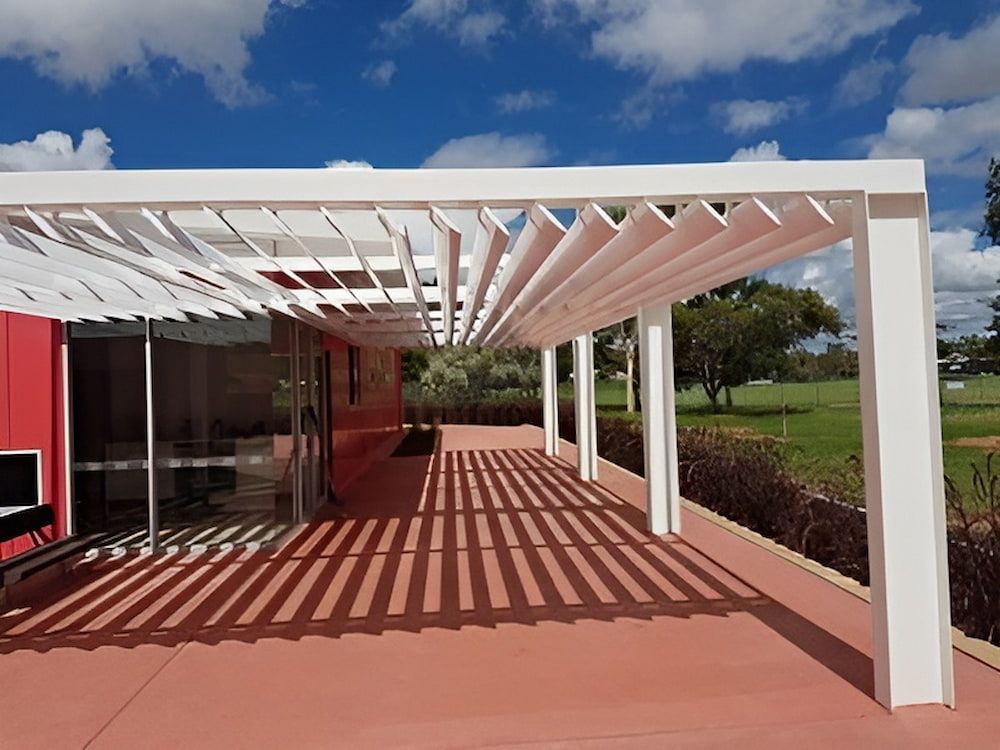 A Red House With A White Pergola Over It — Jakes Steel & Welding in East Arm, NT