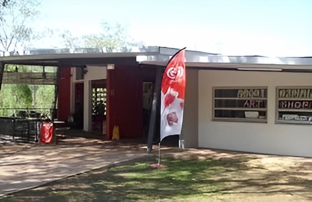 A Building With A Red And White Flag In Front Of It — Jakes Steel & Welding in East Arm, NT