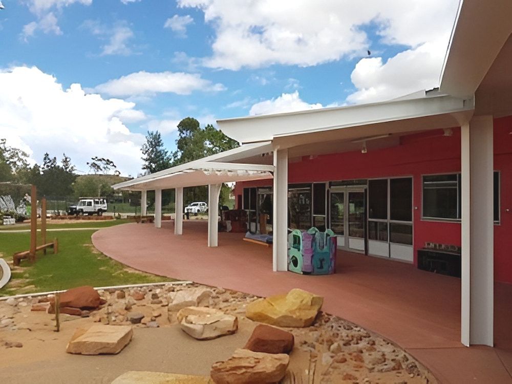 A Red Building With A White Roof And A Playground In Front Of It — Jakes Steel & Welding in East Arm, NT