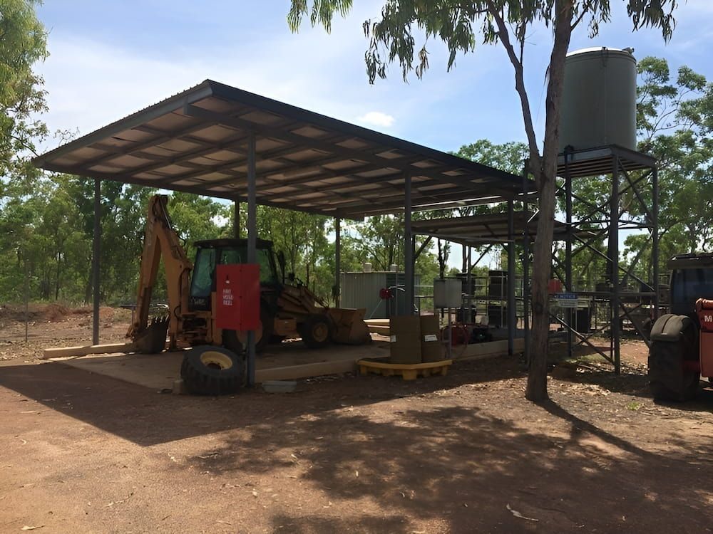 A Tractor Is Parked Under A Canopy In The Dirt — Jakes Steel & Welding in East Arm, NT