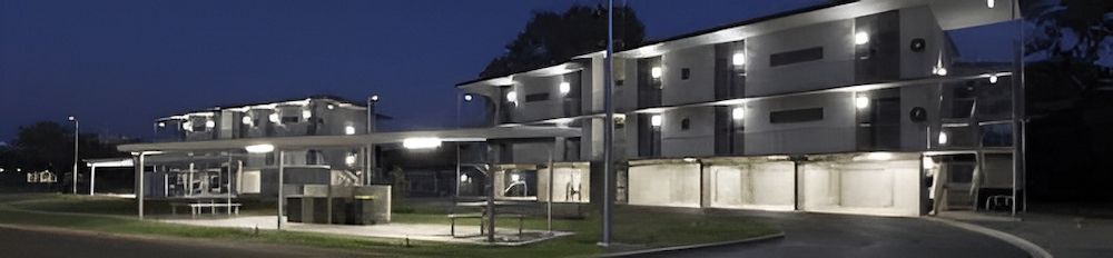 A Row Of Buildings Are Lit Up At Night — Jakes Steel & Welding in East Arm, NT