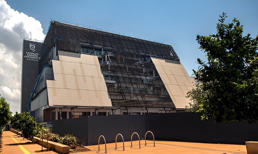 A Large Building Is Under Construction With A Fence Around It — Jakes Steel & Welding in East Arm, NT