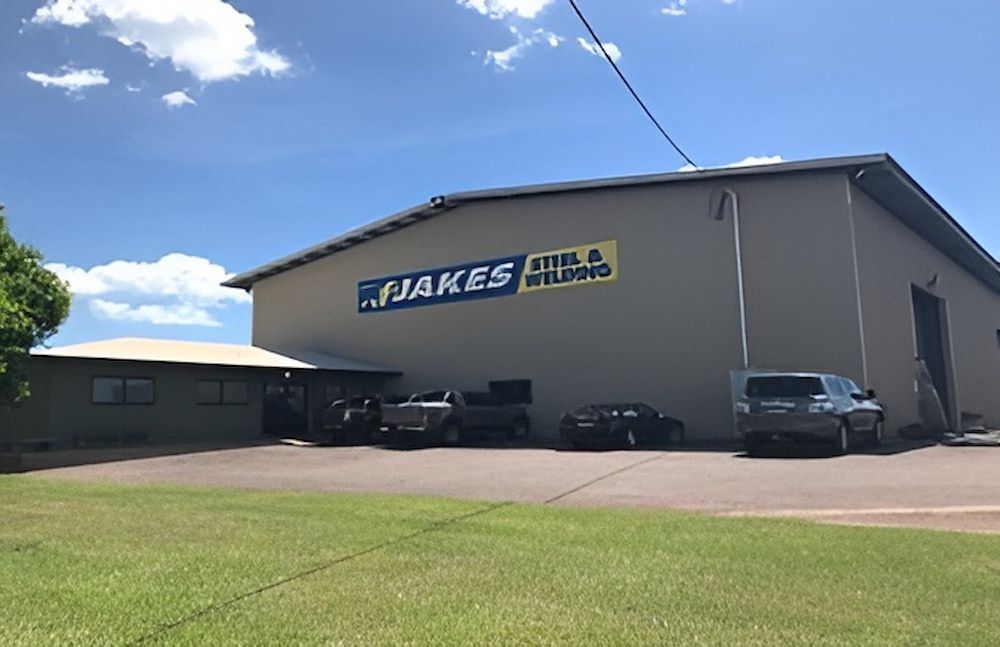 A Large Building With Cars Parked In Front Of It — Jakes Steel & Welding in East Arm, NT