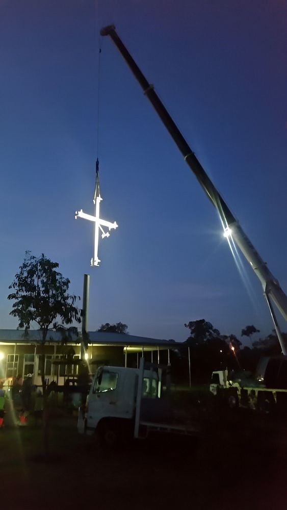 A Large White Cross Is Being Lifted By A Crane — Jakes Steel & Welding in East Arm, NT