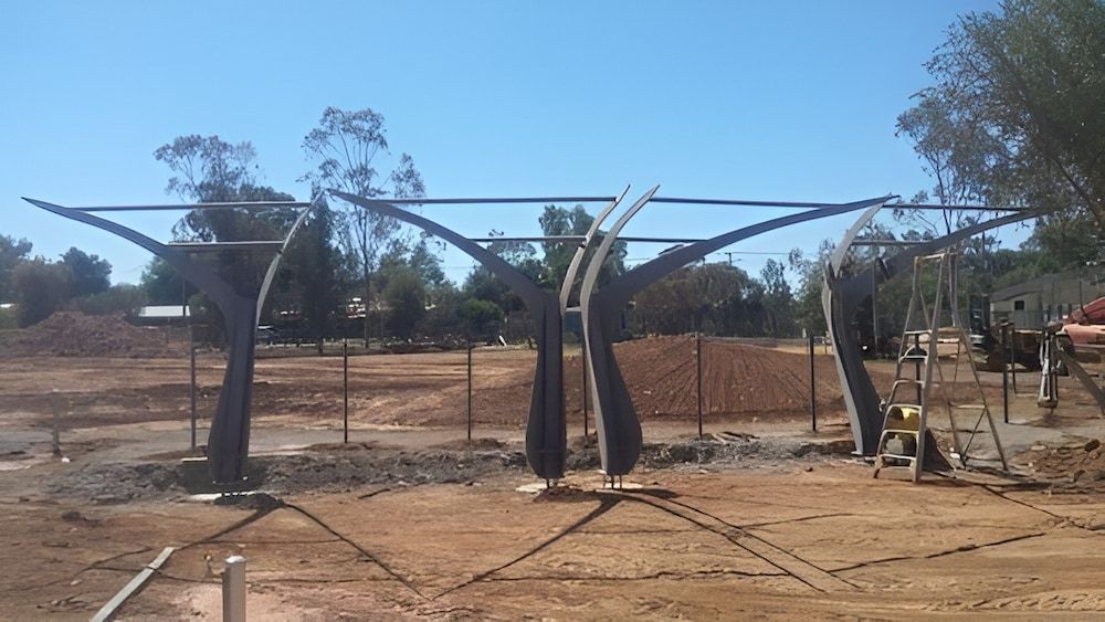 A Large Metal Structure Is Being Built In A Dirt Field — Jakes Steel & Welding in East Arm, NT