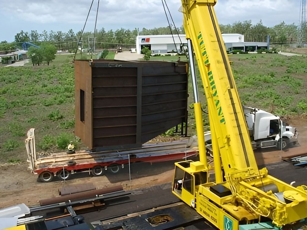A Yellow Crane Is Lifting A Large Piece Of Metal — Jakes Steel & Welding in East Arm, NT