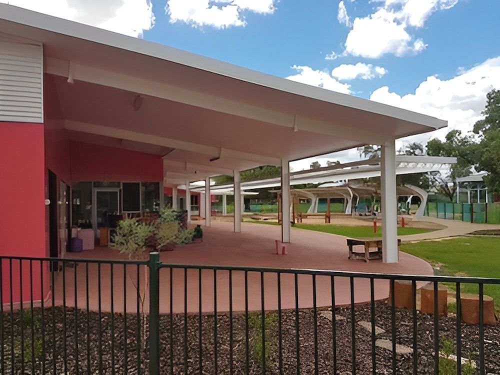 A Large Red Building With A Fence Around It — Jakes Steel & Welding in East Arm, NT