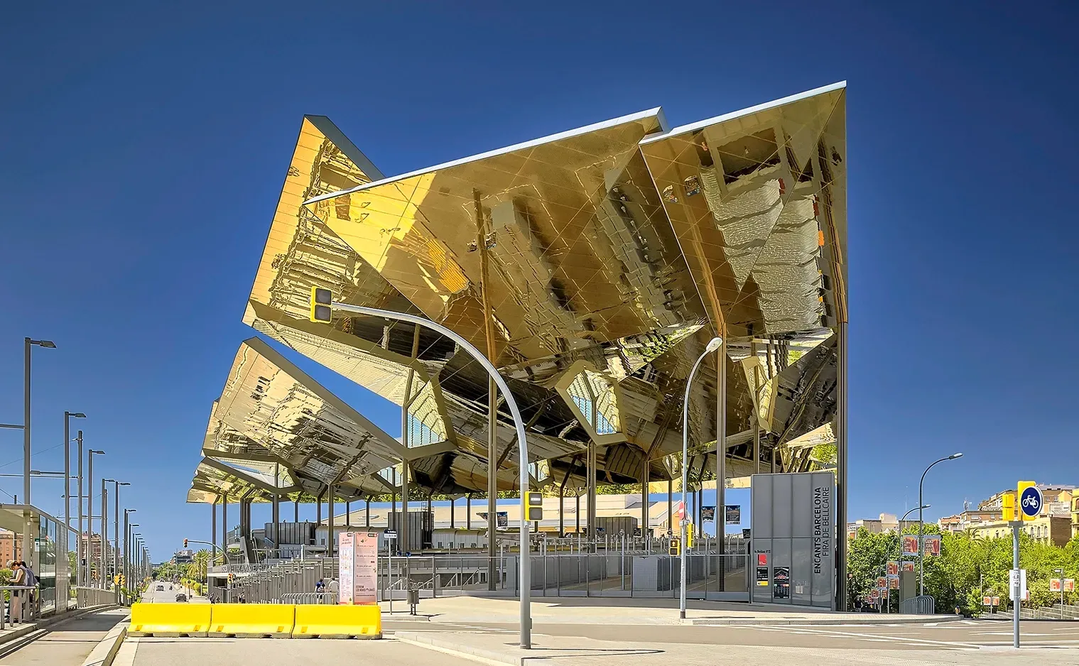 Golden-mirrored architectural structure with angled roof sections reflecting the sky and surroundings.