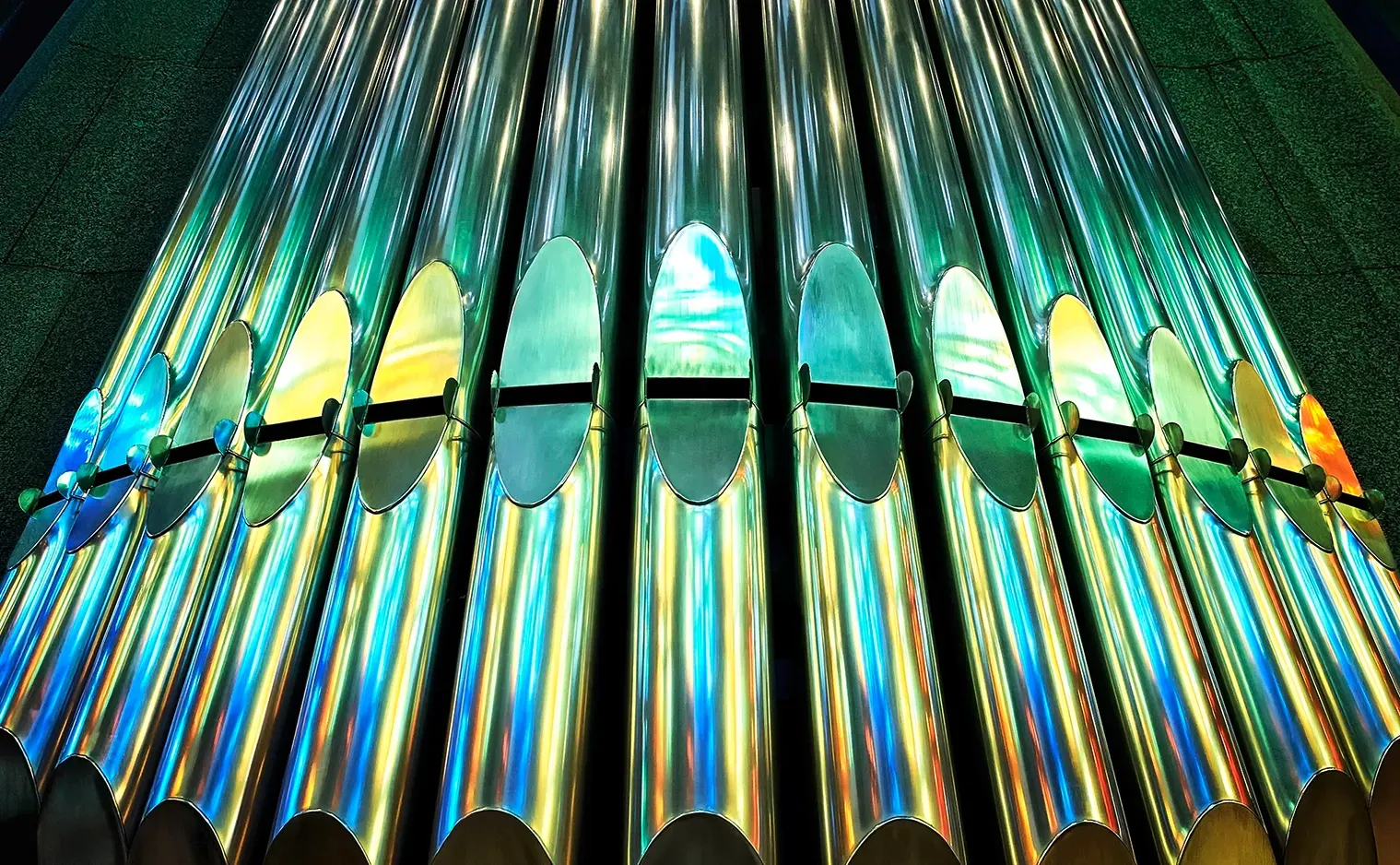 Shiny, metallic organ pipes with colorful reflections.