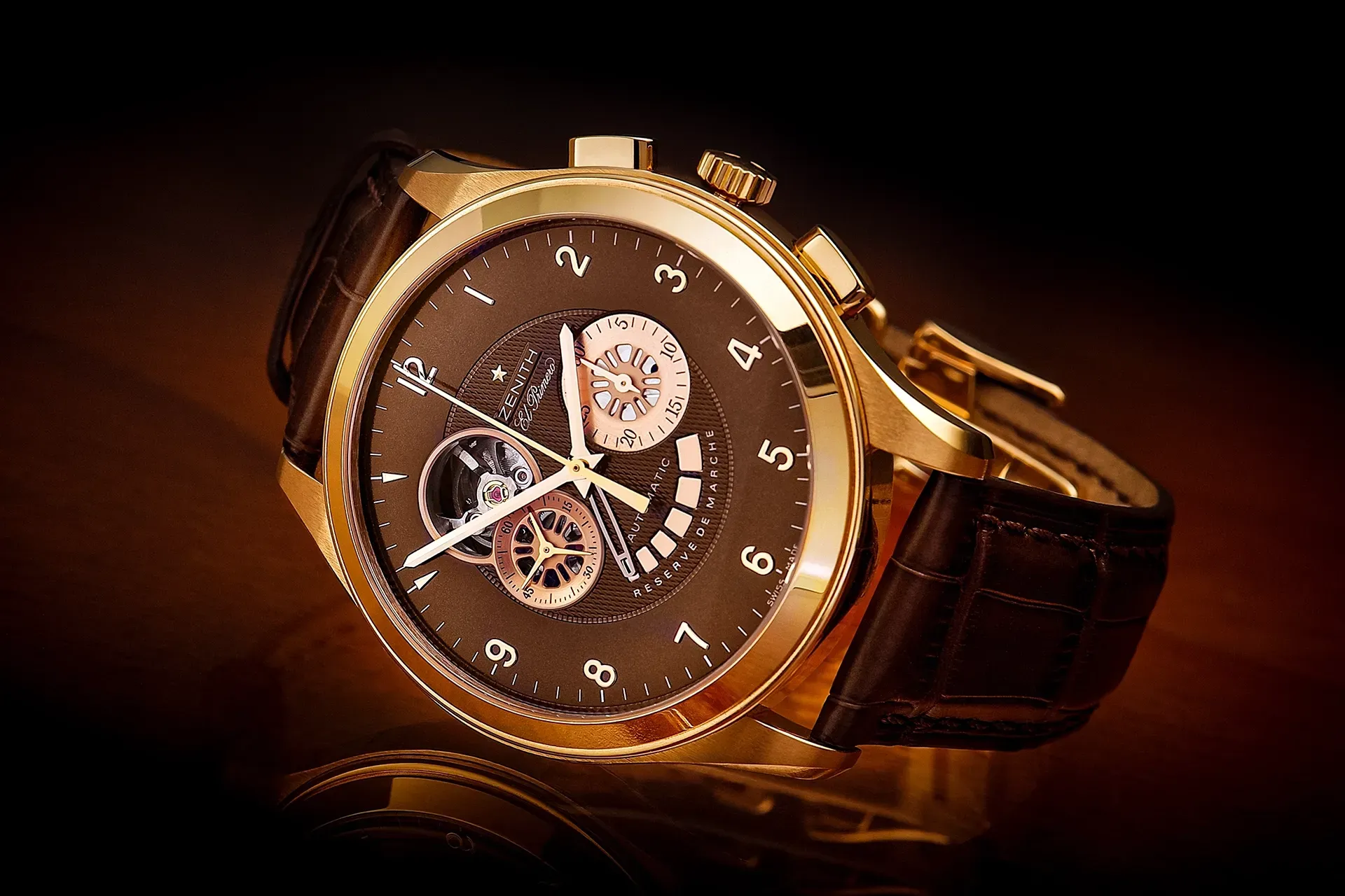 Gold wristwatch with dark face and black leather band.