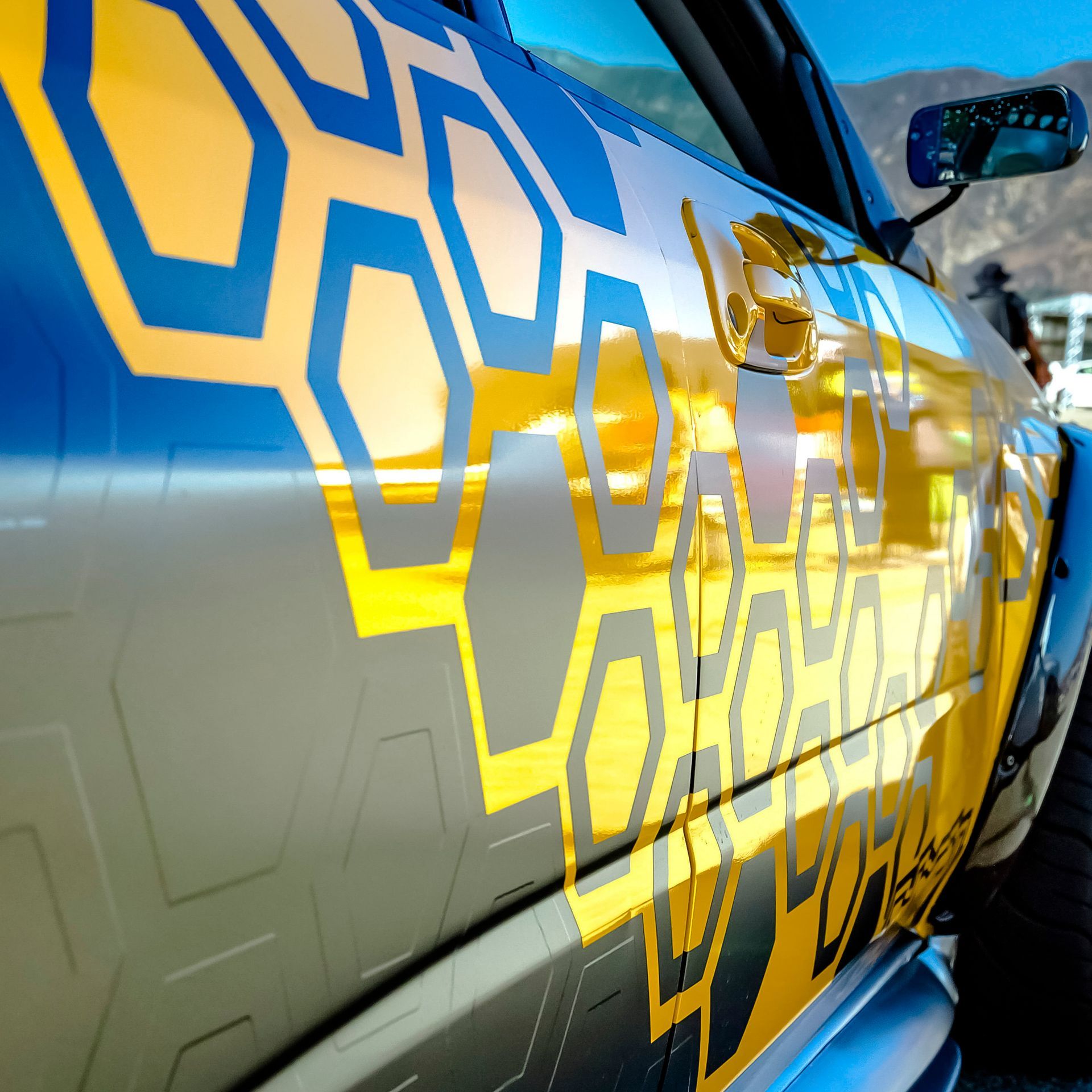A blue and yellow car with a honeycomb design on it