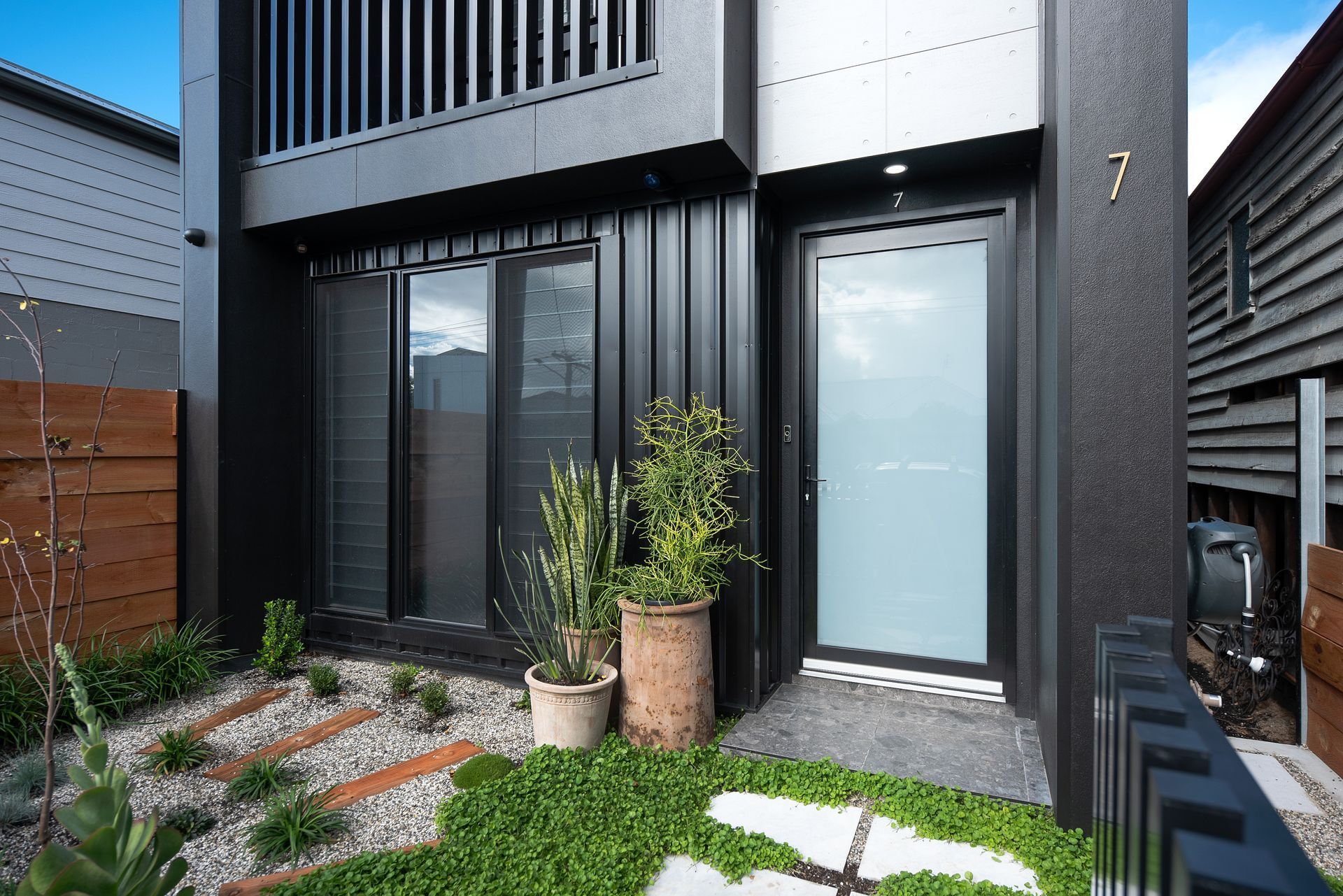 Modern custom home two storey home entrance with landscaped front courtyard by Yarrum Designer Homes