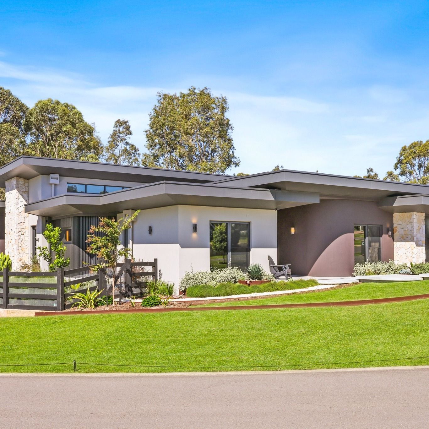 Single-storey custom home at Pokolbin with flat rooflines, stone accents and a landscaped lawn