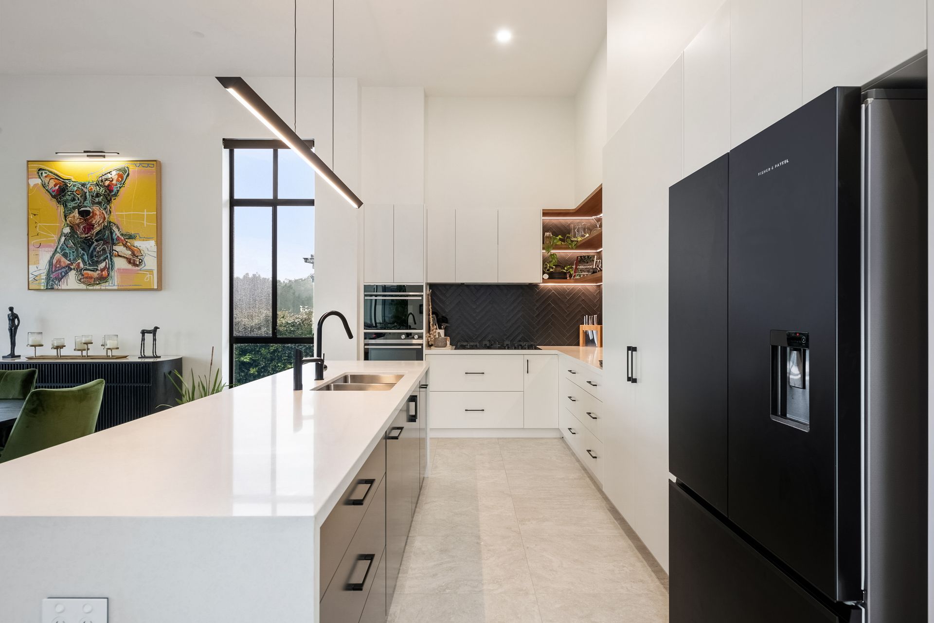 Yarrum custom design modern kitchen with white cabinetry, stone island bench, and black fridge 