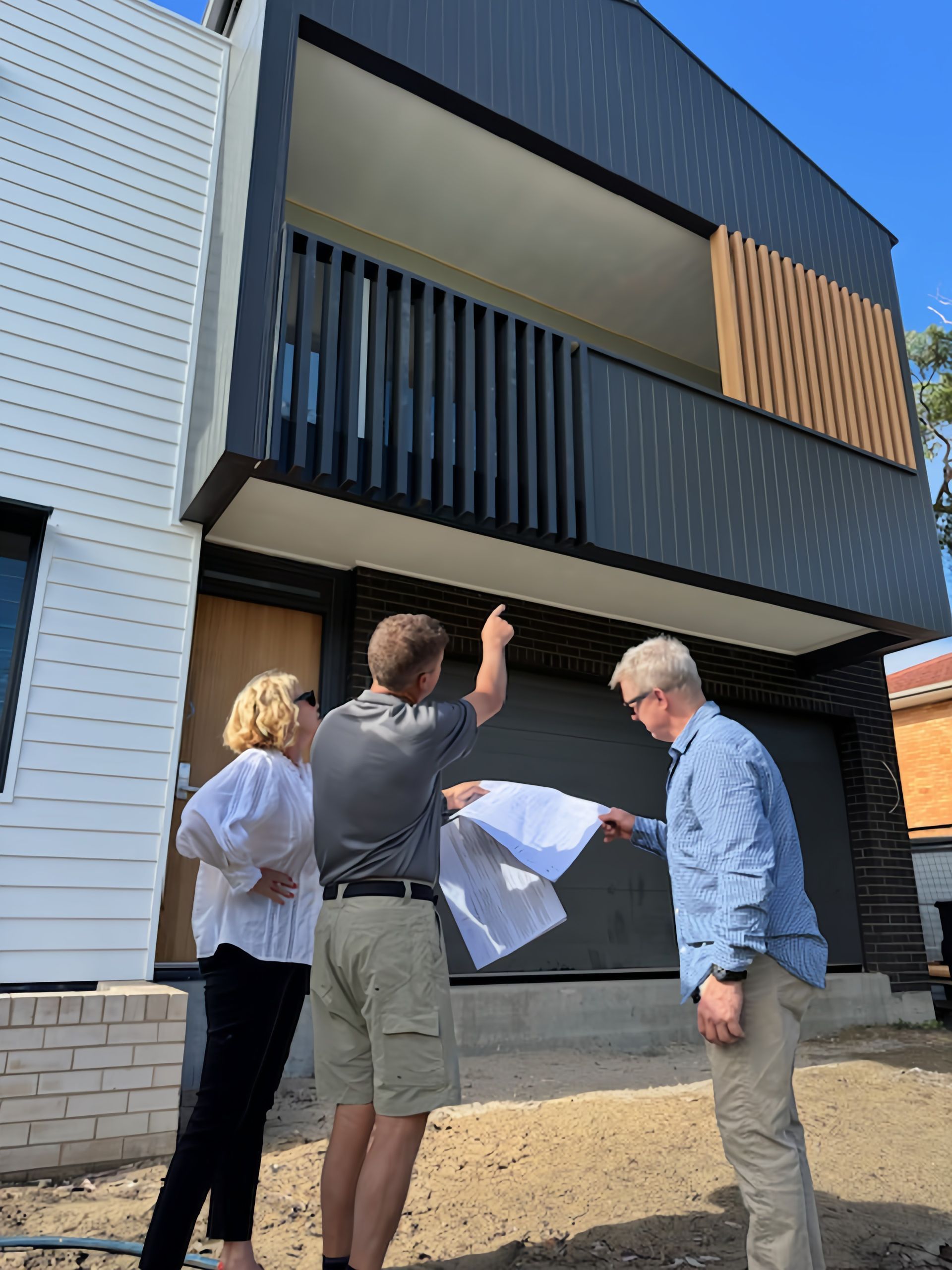 Architect and homeowners reviewing house plans during construction in Port Macquarie