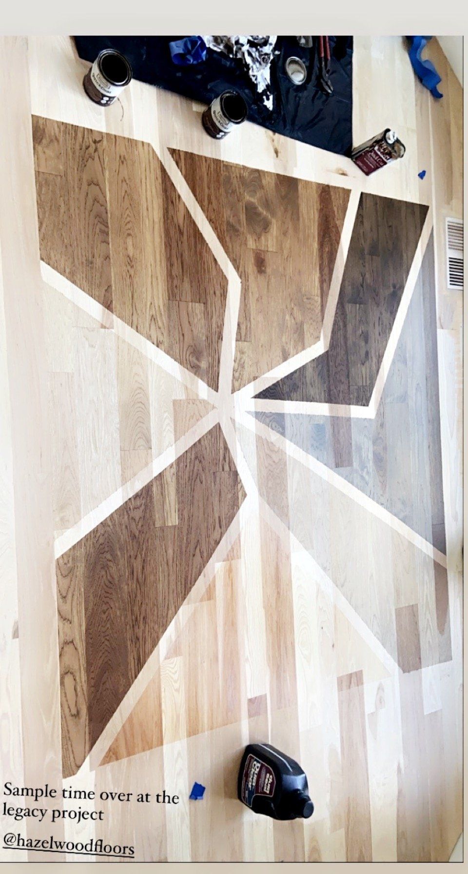 Wooden floor with taped geometric pattern and a few objects along the top edge