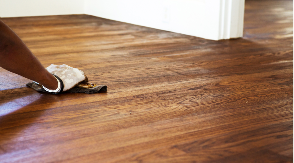Person mopping a hardwood floor in a bright room