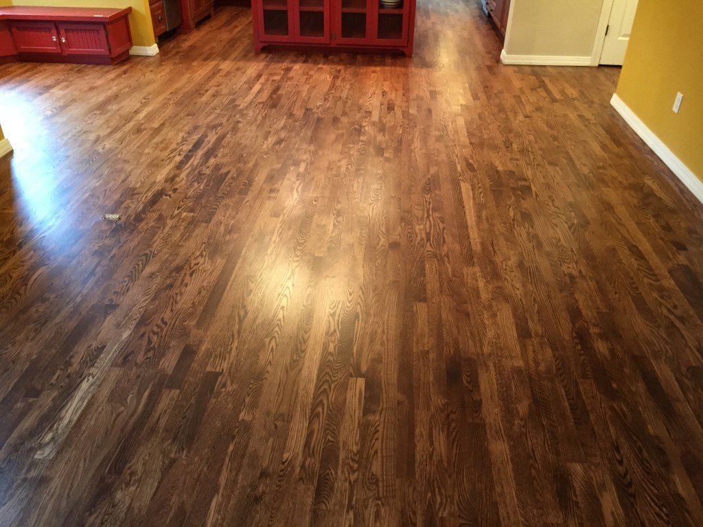Empty room with wood-look flooring, red built-in cabinets, and yellow walls.