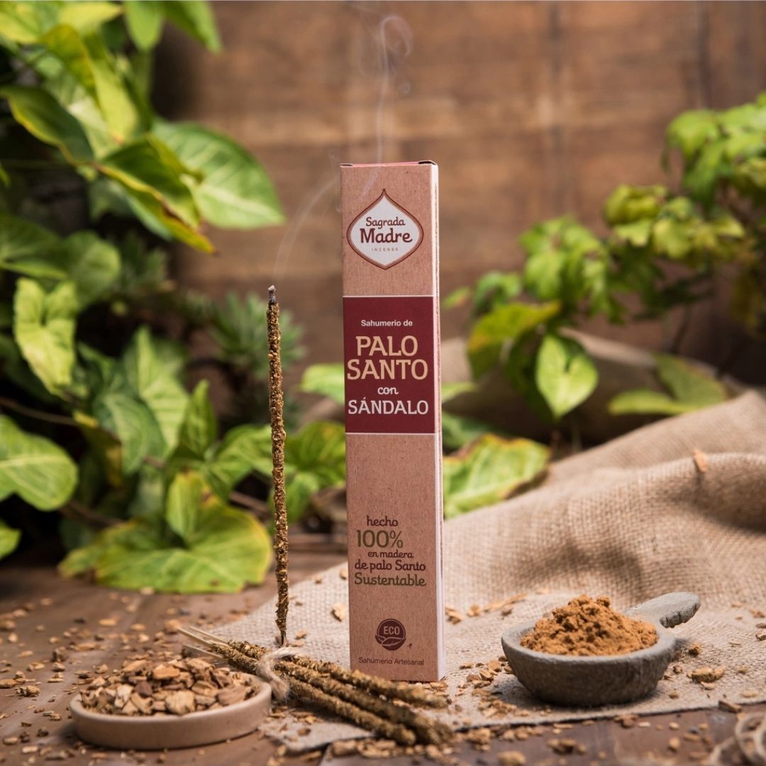 Caja rosa con varitas de incienso de palo santo y sándalo, con varitas sueltas en la parte delantera.