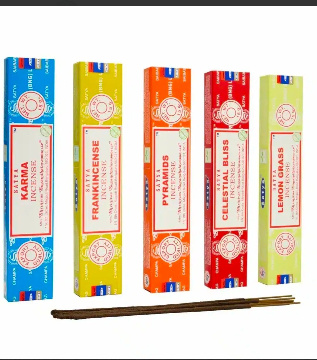 Cajas coloridas apiladas con varitas de incienso surtidas, dispuestas en forma de pirámide.