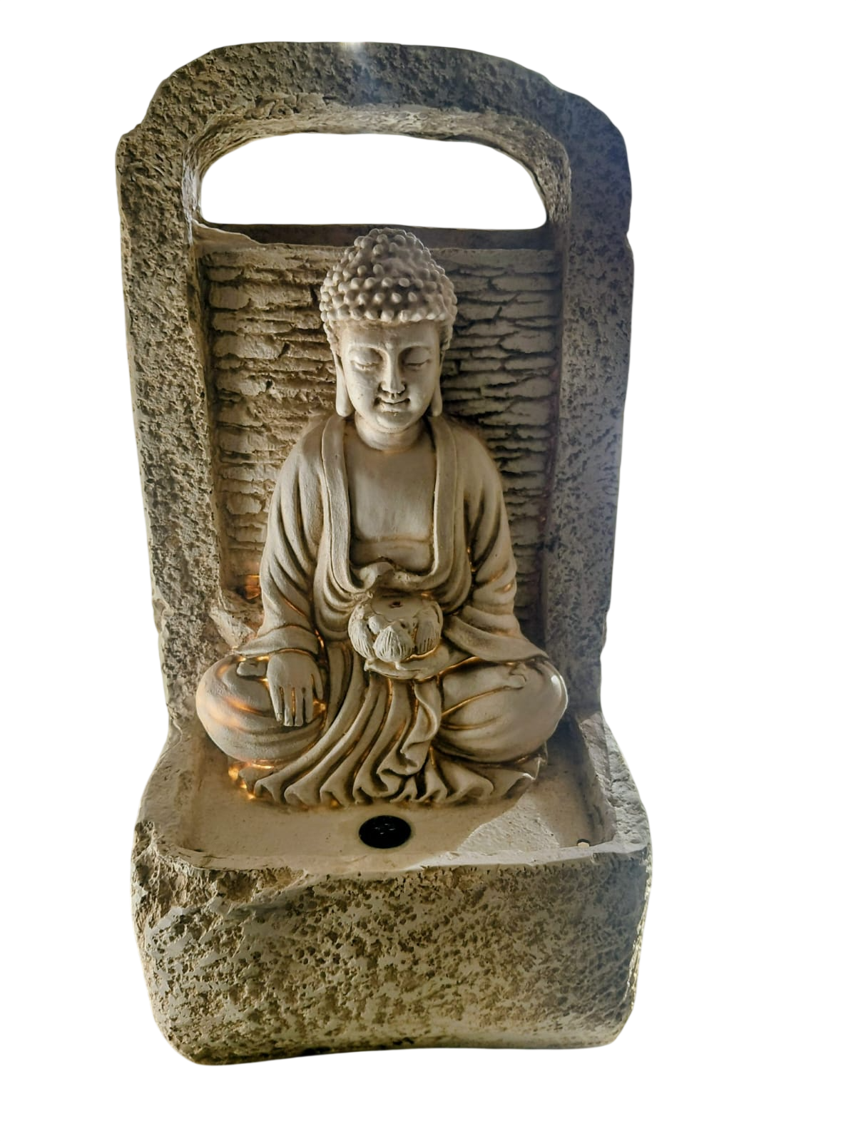 Estatua de Buda de piedra en un nicho empotrado sobre un pedestal texturizado, con un arco tallado y un candelabro.
