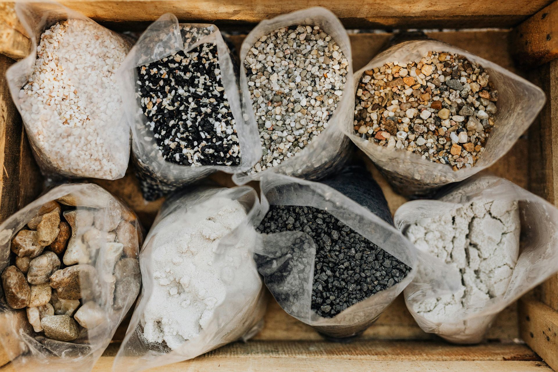 Assorted spices and seasonings in small paper bags inside a wooden crate