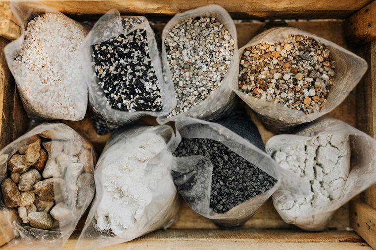 Assorted spices and seasonings in small paper bags inside a wooden crate