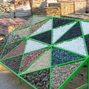 Green metal rack holding stacked firewood in an outdoor yard, with geometric white and black panels on top