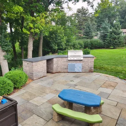 Custom backyard outdoor kitchen in Loretto MN designed for grilling dining and outdoor entertaining